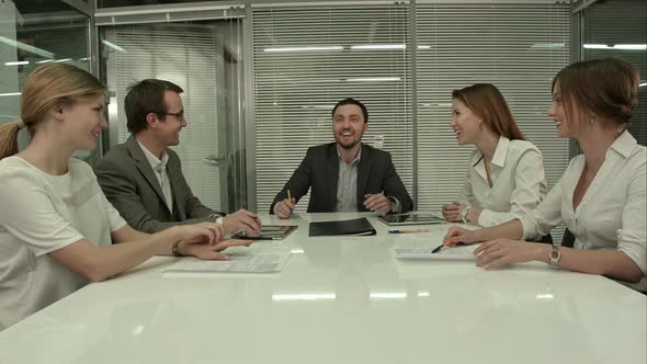 Casual Business Team Laughing During Meeting in the Office