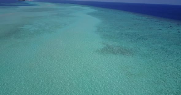 Wide angle overhead clean view of a paradise sunny white sand beach and aqua blue water background i