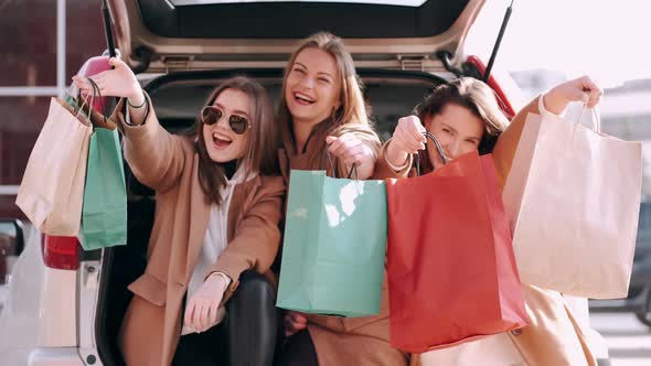 Attractive Girls Have Shopped and Checking Purchases at the Car Back