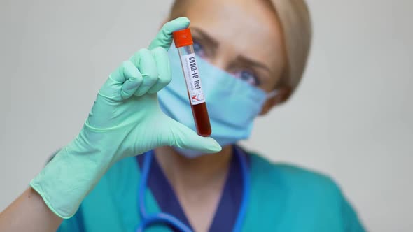 Medical Doctor Nurse Woman Wearing Protective Mask and Gloves - Holding COVID-19 Negative Blood Test