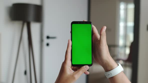 Using Smartphone in Horizontal Mode with Green Mockup Screen