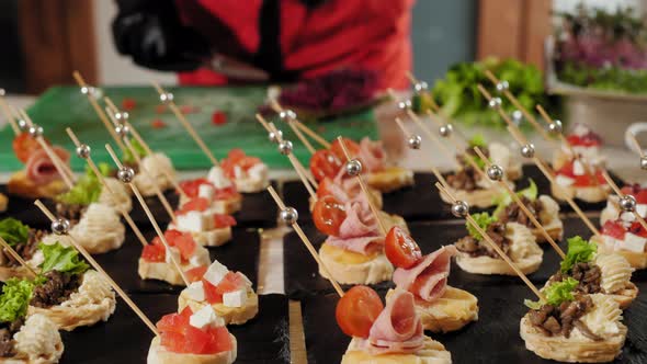 Closeup View of Chef Decorating Gourmet Canapes with Microgreens