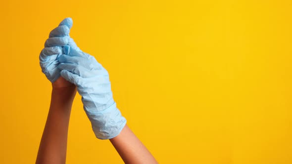 Man Doctor Wears Medical Gloves Against Yellow Background