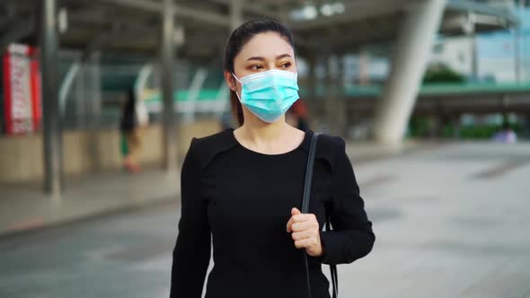 slow-motion of business woman walking and wearing medical mask for protection from coronavirus