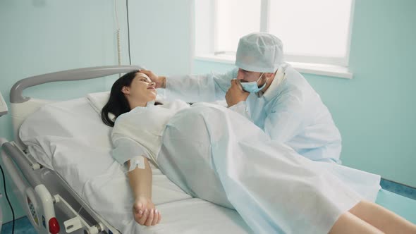 Pregnant Woman with Painful Contractions Holding Hand of Her Caring Husband That