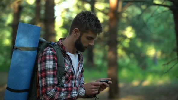 Male Lost in Forest Using Compass to Navigate