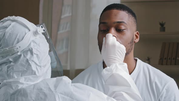 Unrecognizable Doctor Nurse Medical Worker in Protective Uniform Makes Pcr Test to African American