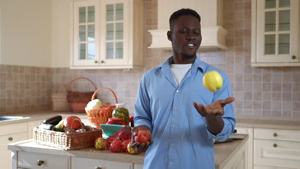 Positive African American Man Juggling Organic Vitamin Apples Smiling Looking at Camera