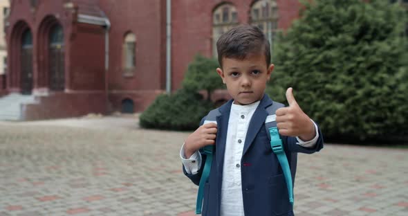 Close Up View of Little Kid with Backpack Looking To Camera, Portrait of Cute Boy in Uniform Showing