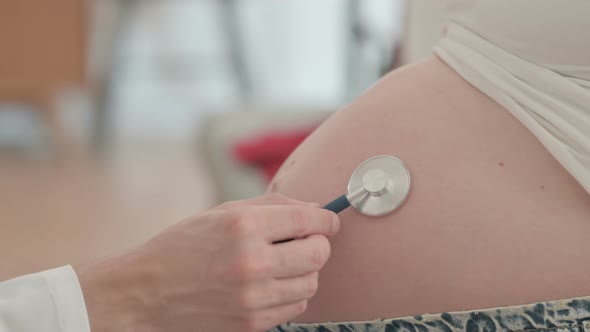 Doctor Listening Pregnant Belly of Woman with Stethoscope