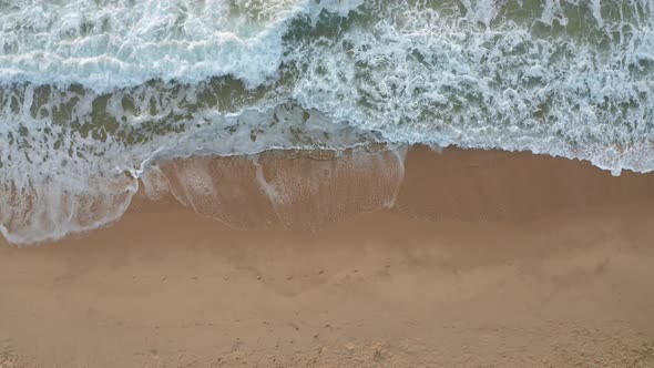 Top view of empty sandy beach and picturesque sea waves