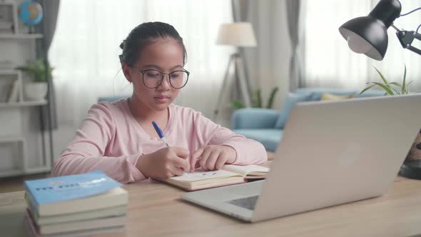 Teenage Girl With Laptop Doing Homework At Living Room