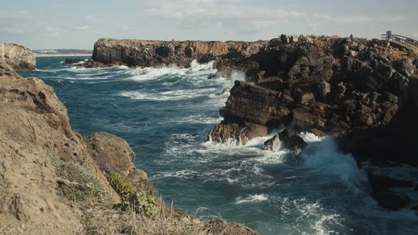 Huge waves splashing against cliffs.