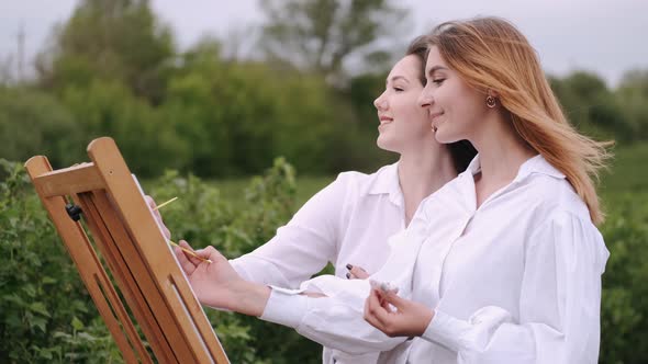 Elegant and Beautiful Girls Painting in a Field