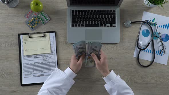 Doctor Counting Dollar Banknotes, Reward for Health Care Services, Top View