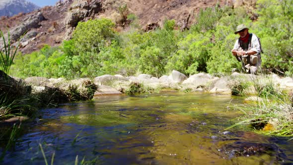 Fisherman fly fishing in river