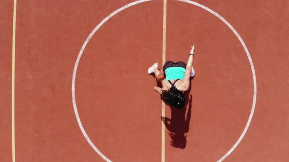 Aero, Top View, Fitness Woman in Sportswear Doing Various Exercises. Background of Orange Basketball