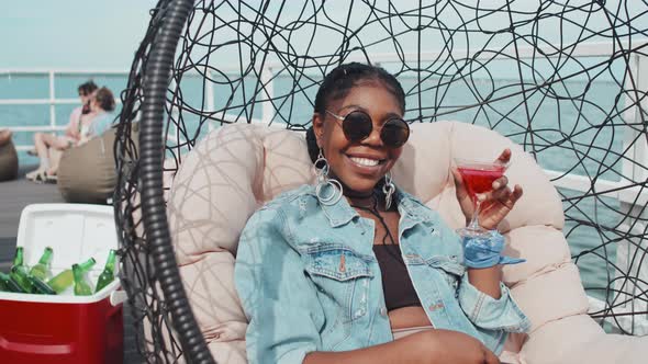 Girl with Cocktail in Hanging Chair