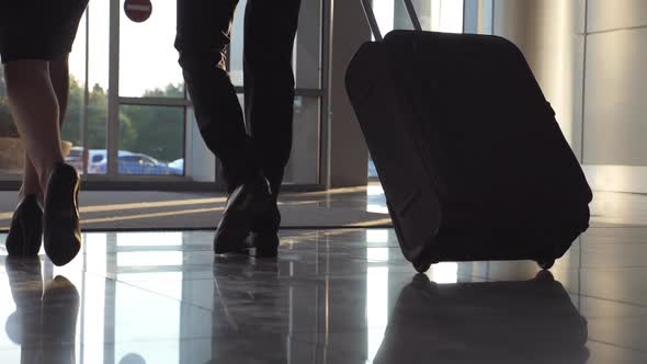 Business People Leaving Airport Through Automatic Glass Door with Their Luggage. Young Man and Woman