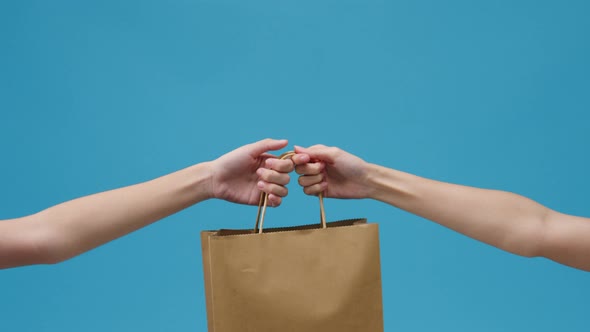 Young woman hand hold brown clear empty blank craft paper bag food for takeaway.