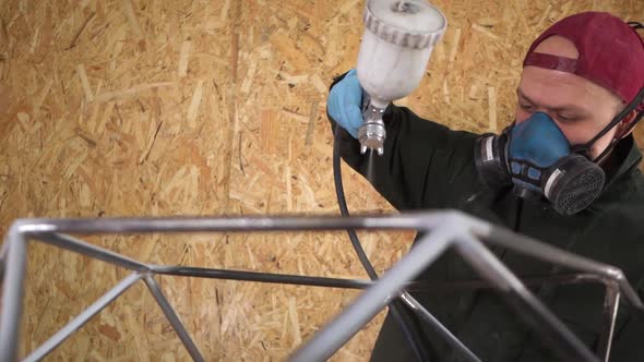 Worker Paints Metal Products With Airless Spray. The Camera Pans Around the Subject. Slowmotion