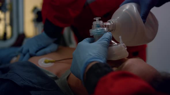 Paramedics Hands Providing First Aid Help of Man with Cardiac Respiratory Mask