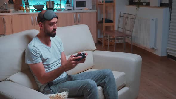 Frustrated Man with Sleep Mask Losing Videogame Competition