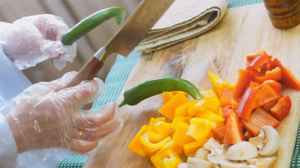 The Chef Cuts Green and Hot Peppers with a Professional Knife