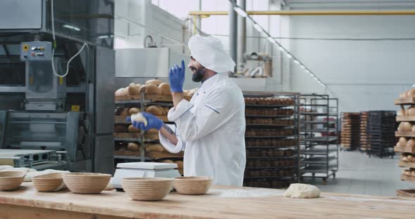 Charismatic Baker with Beard in a Big Bakery