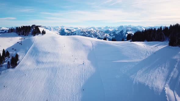 Ski in the Alps with ski lift and people skiing on the slope. Aerial view