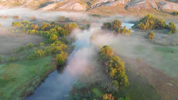 Aerial Drone View of Sunrise Over Misty River