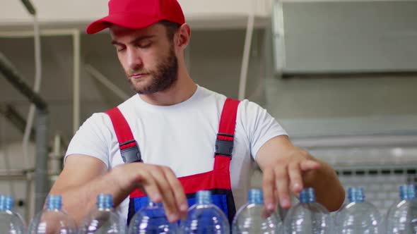 Young Man Worker of Water Factory Checking Quality and Making Inspection in Line Production