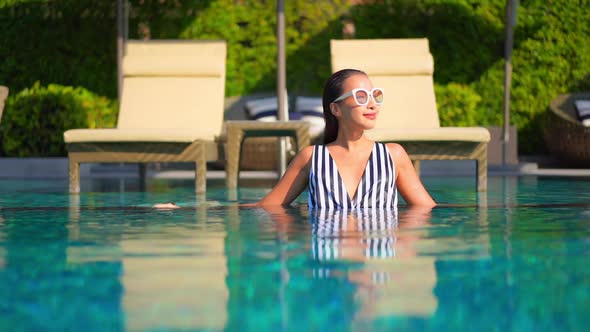 Young asian woman enjoy around outdoor swimming pool for leisure