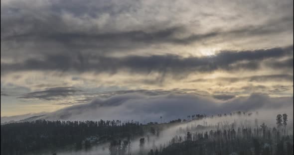 Timelapse of Evening Sun Rays Emerging Through the Cold Foggy Clouds in the Mountains