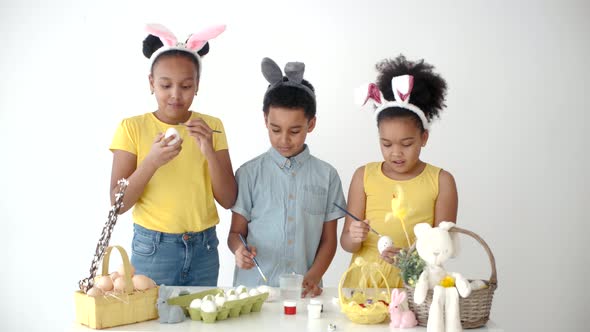 African American Kids in Funny Bunny Ears Colouring Eggs on Easter