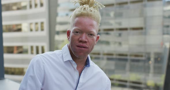 Portrait of happy albino african american businessman in creative office