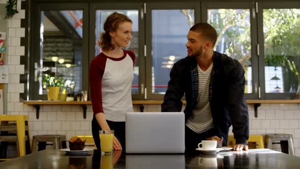 Man and woman executive discussing over a laptop in office cafeteria 4K 4k