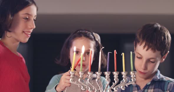 Children lighting Hanukka candles at home