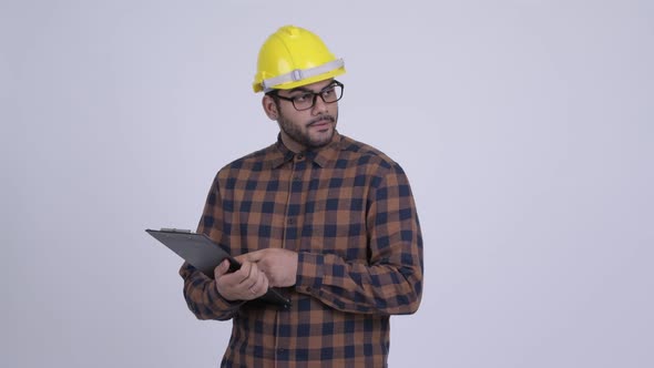 Young Bearded Indian Man Construction Worker Reading on Clipboard