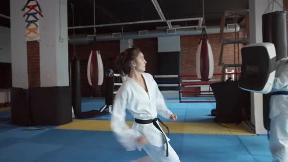 Pair of Female Kickboxers Practicing Kicks