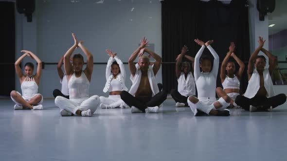 Multi-ethnic group of fit male and female modern dancers practicing dance routine