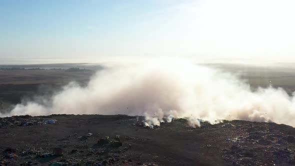 Aerial view of smoke from burning garbage pile in landfill, Earth pollution concept