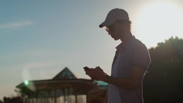 Man Stood Near Beach Making Purchase on His Mobile.