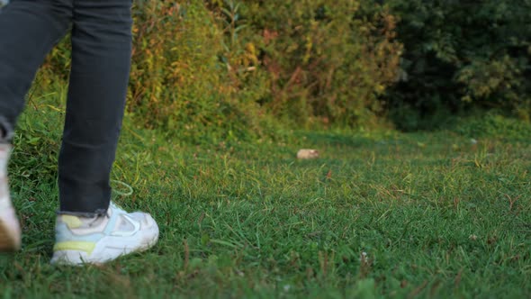 Unrecognizable Teenager Throws a Plastic Bottle in the Grass