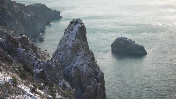 Snow Covered Rocky Cliffs Over Sea