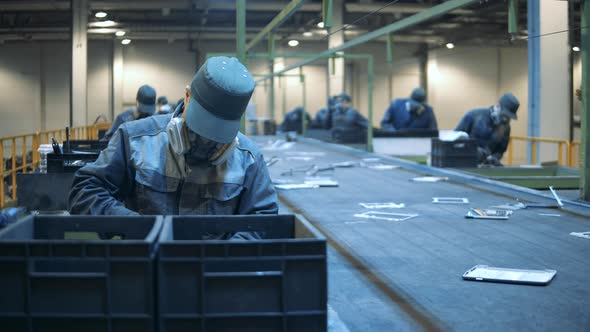 Defective Electronics Is Being Sorted By Landfill Workers. Male Factory Employees Are Sorting Waste.