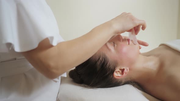 Beautiful Brunette Woman in Spa Salon on Massage with Gouache Stones