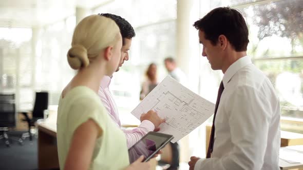 Businessman explaining design details to colleagues