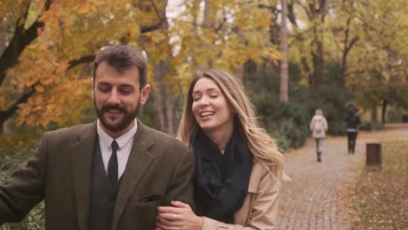Handsome young couple walking in the autumn park