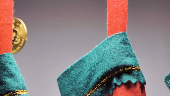 Man Hand Puts Bitcoin Into Christmas Sock Closeup
